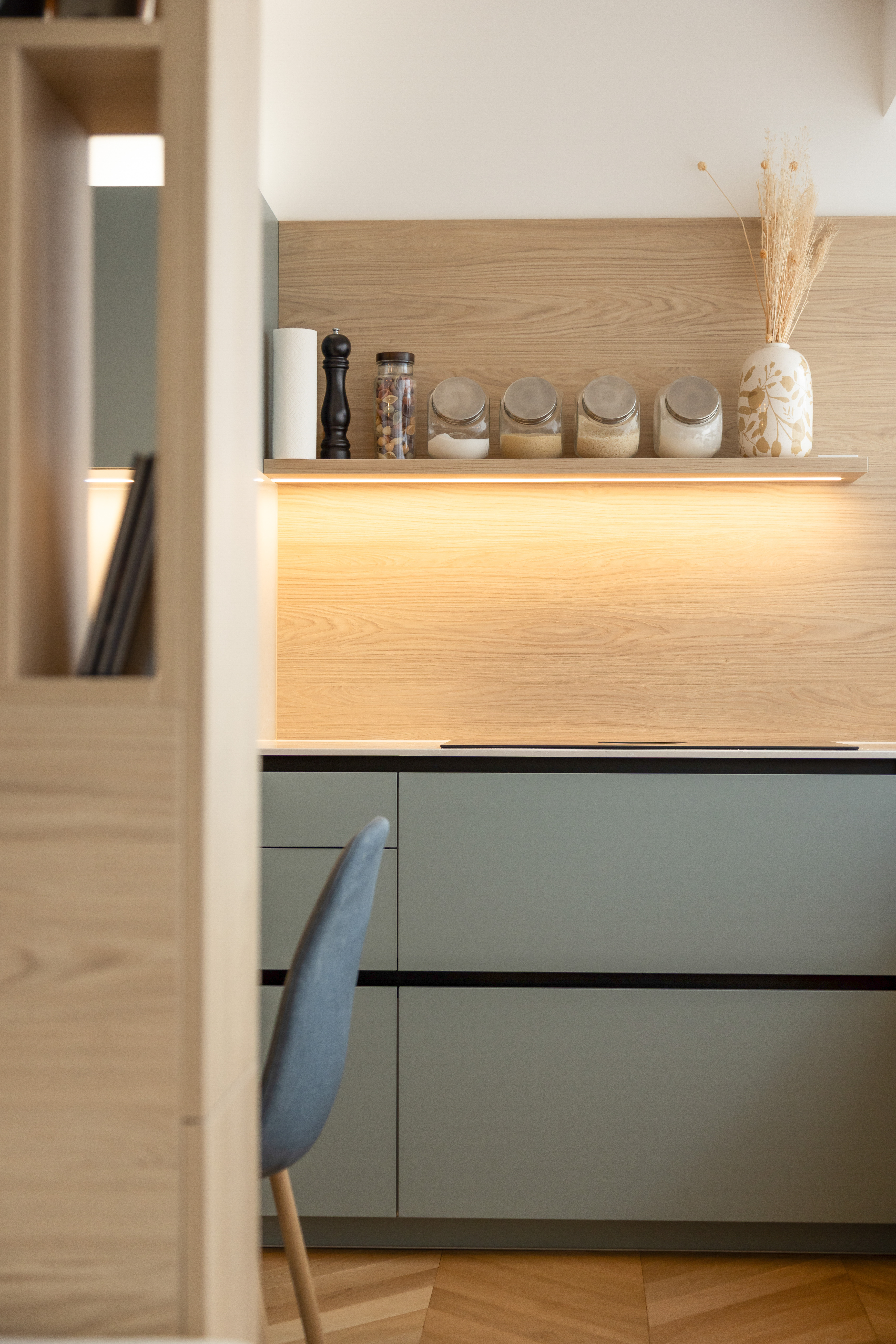 agencement sur mesure.séparation d’espace semi-ouverte.rangements intégrés.harmonie des matériaux.ambiance naturelle bois clair.luminaires suspendus design.continuité visuelle