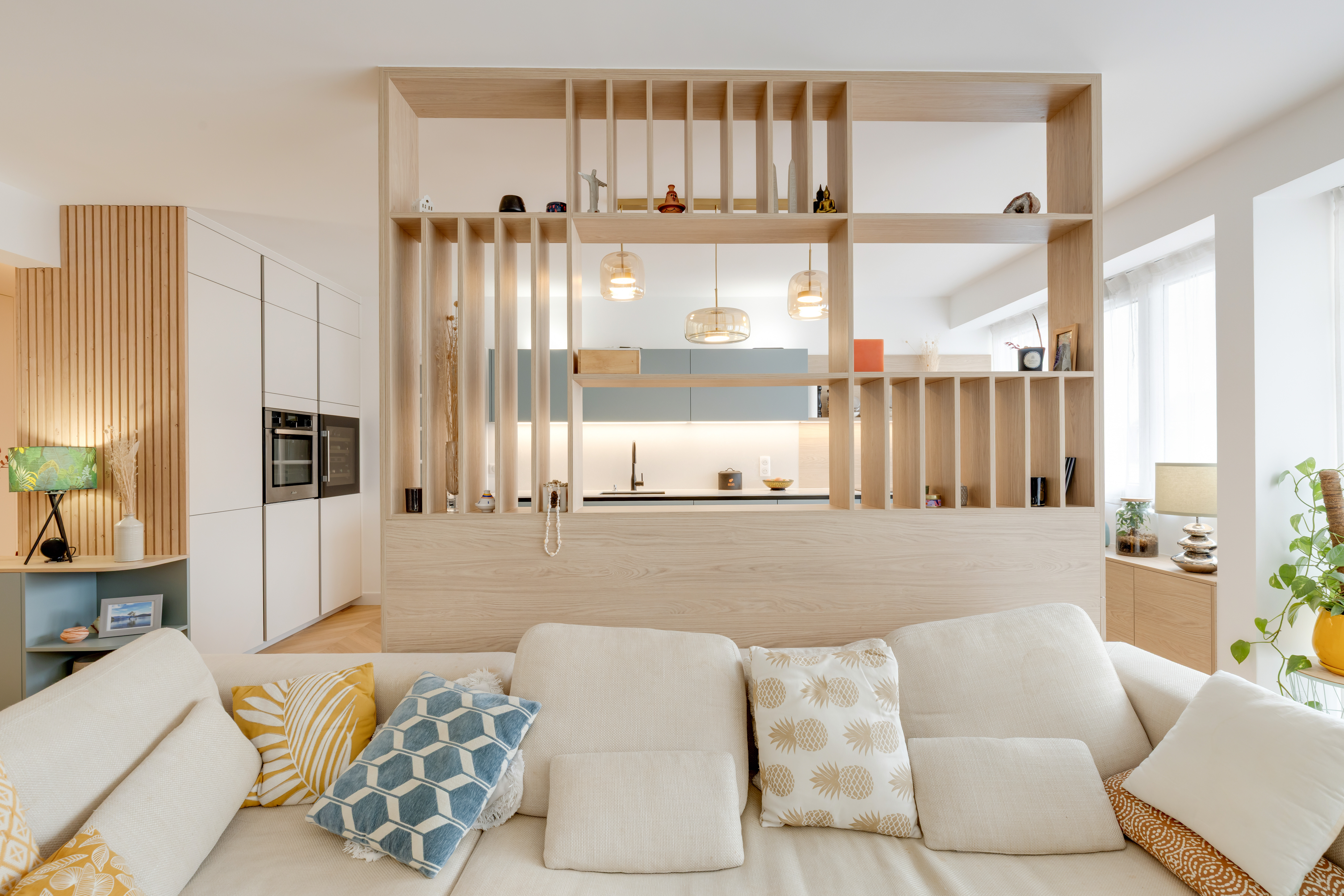 rénovation complète appartement Boulogne-Billancourt.entrée avec banc de rangement intégré.cloison bois ajourée sur mesure.cuisine design avec ilot central.mobilier intégré en